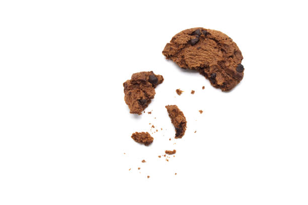 istock Chocolate chip cookies with some broken and crumbs isolated on white background. 1219695624