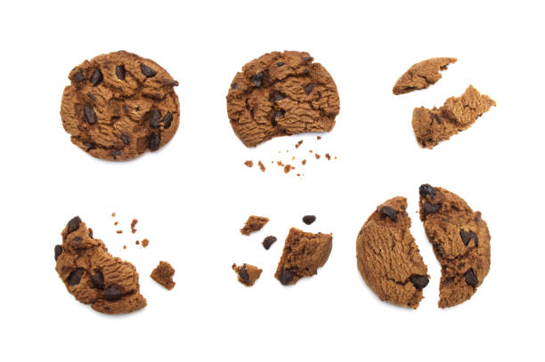 istock Chocolate chip cookies with some broken and crumbs isolated on white background. 1219695630