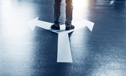 Man standing on white direction arrow.