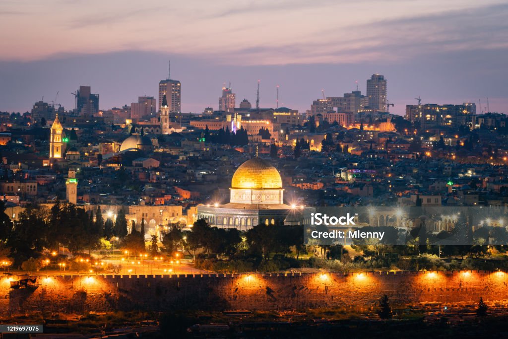 Jerusalem Sunset Twilight Temple Mount at Night Israel Jerusalem Old Town Cityscape of Temple Mount at Sunset Twilight. Holy land view towards the iconic Al-Aqsa Mosque - Golden Dome of the Rock- and Bell Tower of the Church of the Redeemer,  Church of the Holy Sepulchre and Old Town City Wall. Jerusalem Old Town, Israel, Middle East. Palestinian Stock Photo