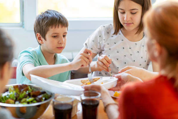 istock Children at the table with mother having take out for lunch 1219697170
