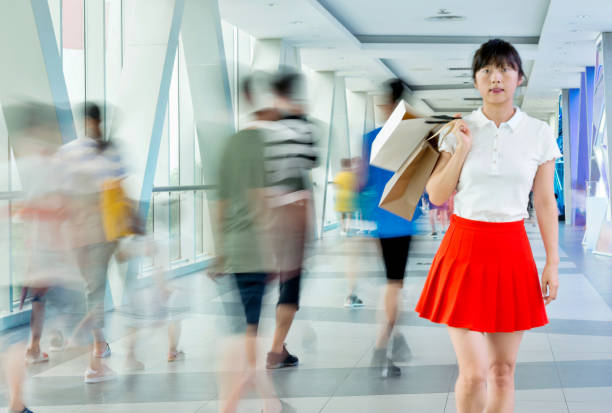 Woman with shopping bags walking on elevated walkway.