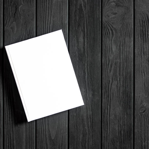 istock Mockup of closed blank square book at white textured paper 1219701733