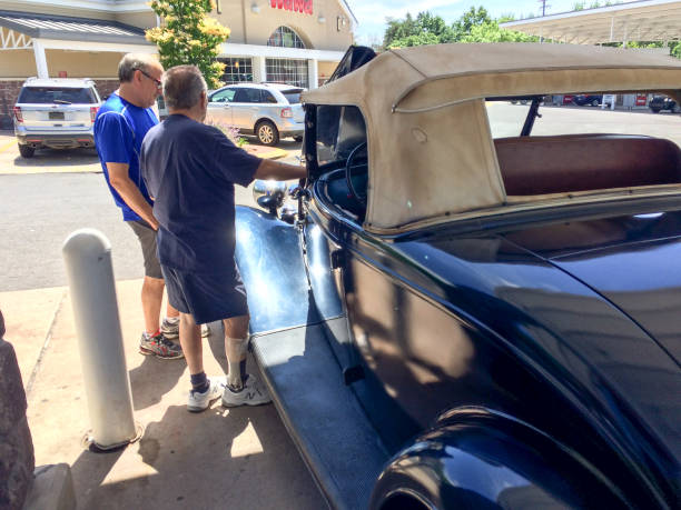 1934 Ford Roadster convertible rumble seat classic automobile Philadelphia, PA, USA - July, 7, 2019, 1934 Ford Roadster blue at gas station with men talking 1934 stock pictures, royalty-free photos & images