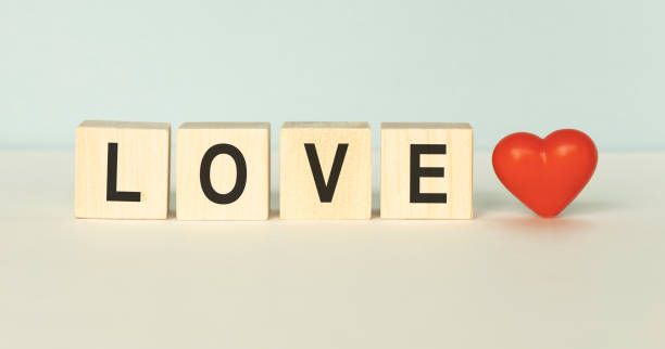istock Heart shaped photo frame with in cube on wood table 1219702877