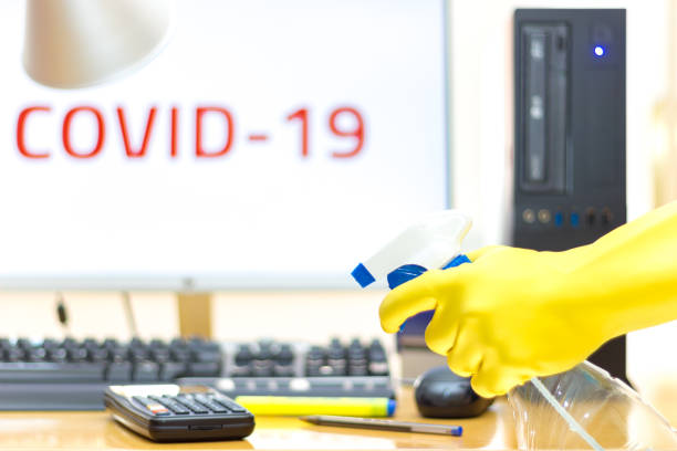 Office disinfection with spray and glove to prevent COVID-19 disease stock photo