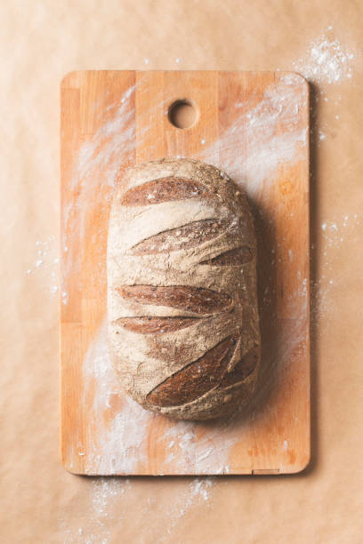 istock Bakery concept with bread and cut board on beige background  flat lay 1219706579