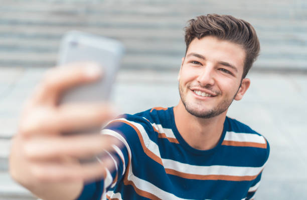 Handsome caucasian guy takes a selfie at the beach stock photo