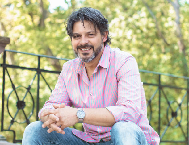 Happy bearded man in the nature sitting in a park, outdoors