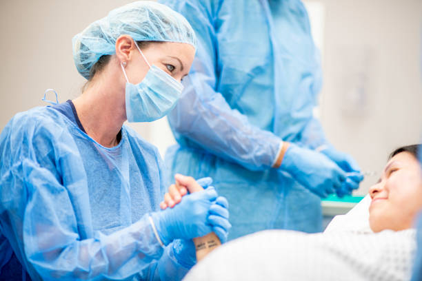 Surgeons in a hospital Team of doctors and nurses wear masks and gloves and prepare for surgery. labor childbirth photos stock pictures, royalty-free photos & images