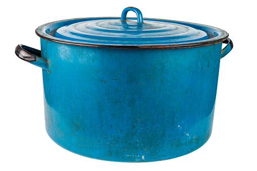 An old large dirty enameled blue pot with cover isolated on white background. Used for heating water for washing in urban ghetto or in poor village. Fifty liters capacity.