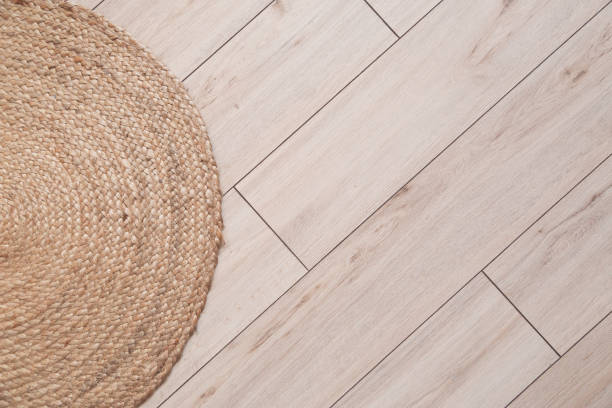 istock Laminate flooring panels with chamfer and wicker carpet. Top view, Background. 1219714809