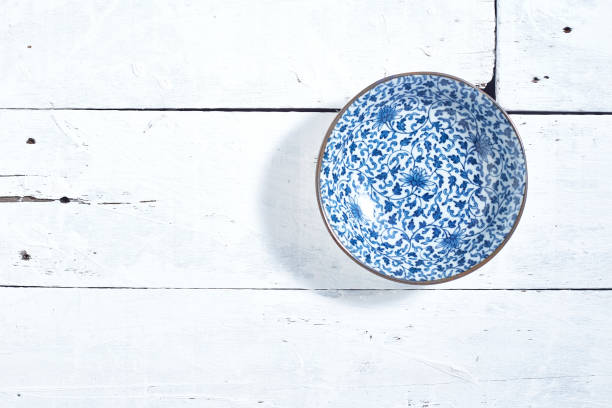 istock Empty ordinary porcelain plate with blue patterns on white wooden table 1219715348