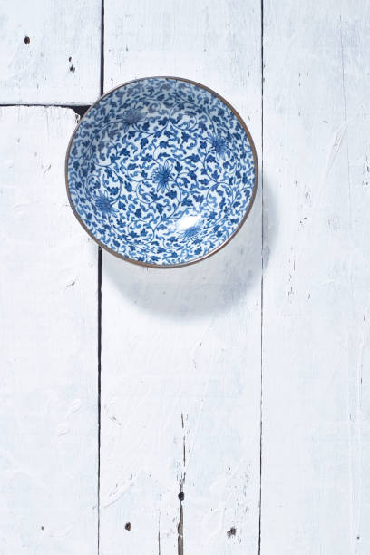 istock Empty ordinary porcelain plate with blue patterns on white wooden table 1219715372
