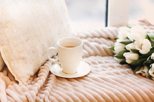 istock Tulips and cup of coffee on bed 1219716173