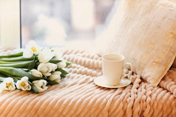 istock Tulips and cup of coffee on bed 1219716279
