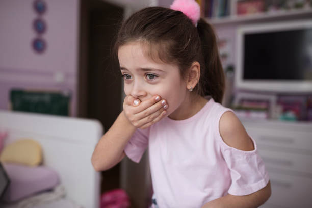 istock Happy child covering mouth when smiling 1219718996