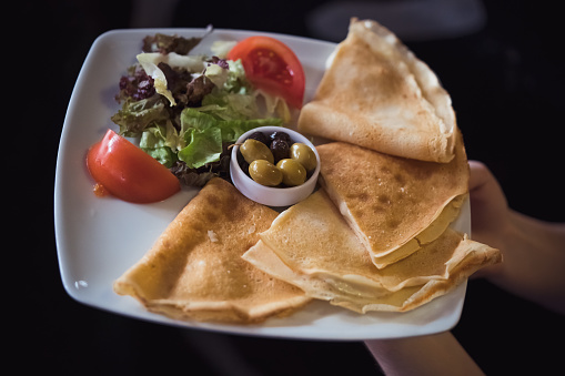 Breakfast plate with crepe and olive.