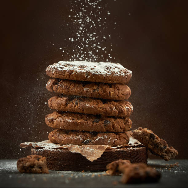 istock Round chocolate cookies are sprinkled with powdered sugar on a brown background. 1219720329