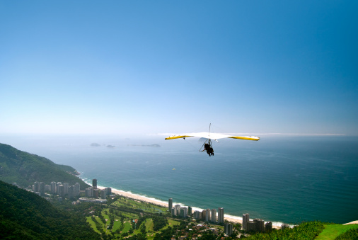 Paragliding in sky. Paraglider tandem flying over the sea and mountains. Extreme sport