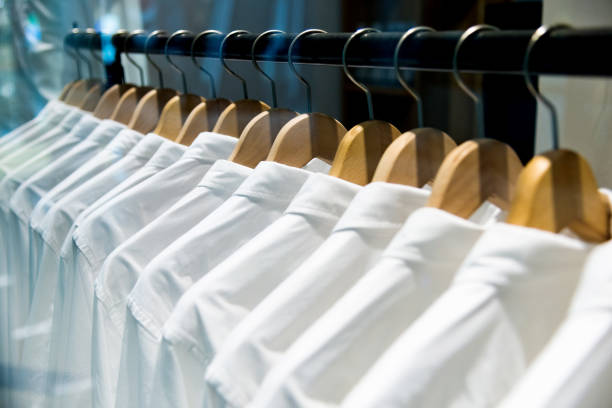istock Group of white shirts hanging on hangers 1219720993