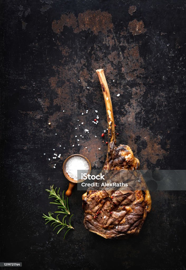 Grilled tomahawk beef steak with spices Grilled tomahawk beef steak with spices on dark rustic background Rib Eye Steak Stock Photo