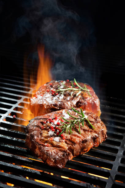 Beef steaks on the grill Beef steaks on the grill with flames steak vertical beef meat stock pictures, royalty-free photos & images