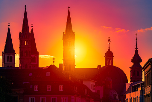 Sunset over city of Wurzburg in Bavaria, Germany. Beautiful sky with sun and clouds in background and old town architecture in foreground