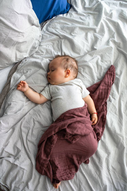 istock Cute Chubby Baby Boy Sleeping on Bed, an Overhead View 1219729088