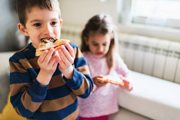 istock Beautiful kids eating pizza 1219729861