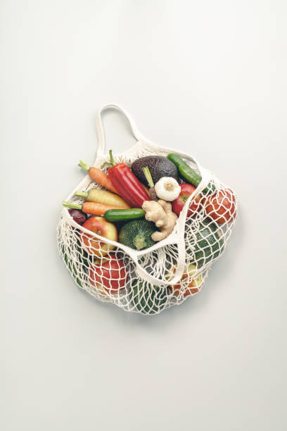 istock Fresh organic fruits and vegetables in mesh textile bag 1219730234