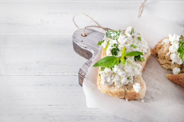 istock sandwiches with soft cheese and herbs on a white wooden background, Basil, Breakfast, top view, copy space 1219731397