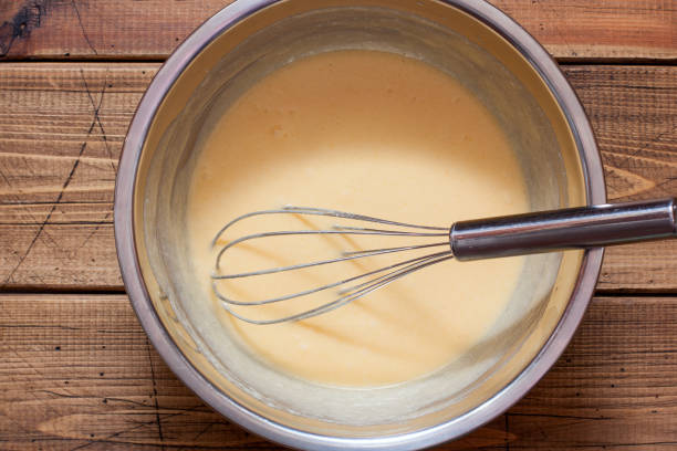 istock Step by step preparation of vanilla muffins, step 3 - adding eggs and vanilla extract, top view, horizontal 1219731496