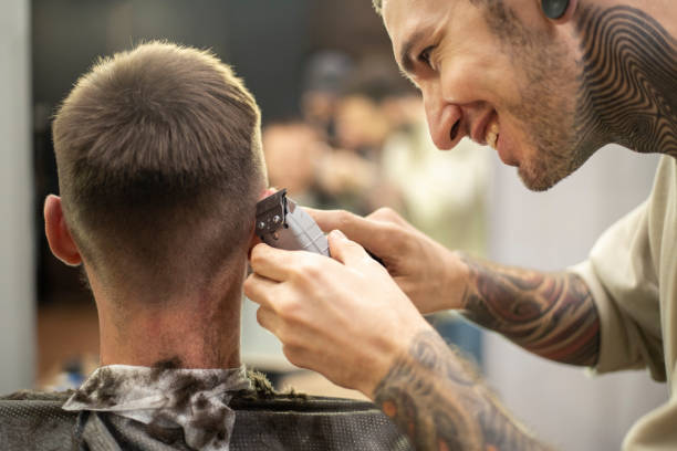 istock Hair stylist using an electric trimmer for hair cut 1219731911