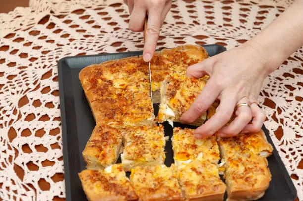 Photo of Top view of woman's hands cutting Brazilian Blender Savoury Pie - Traditional Brazilian food.