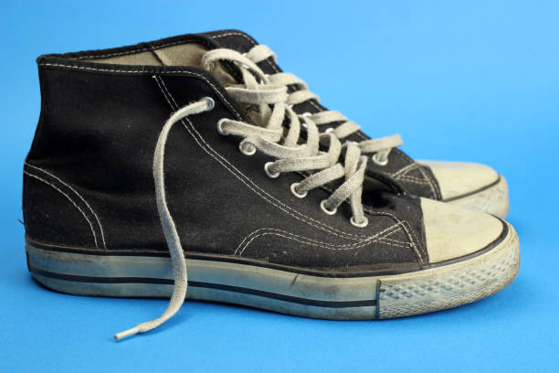 istock sneakers black old, worn, vintage on blue background 1219732008