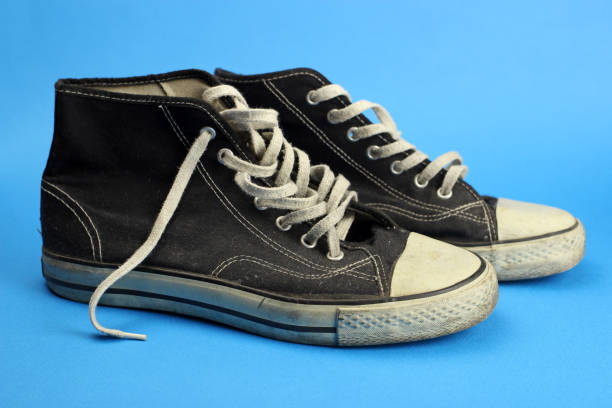 istock sneakers black old, worn, vintage on blue background 1219732028