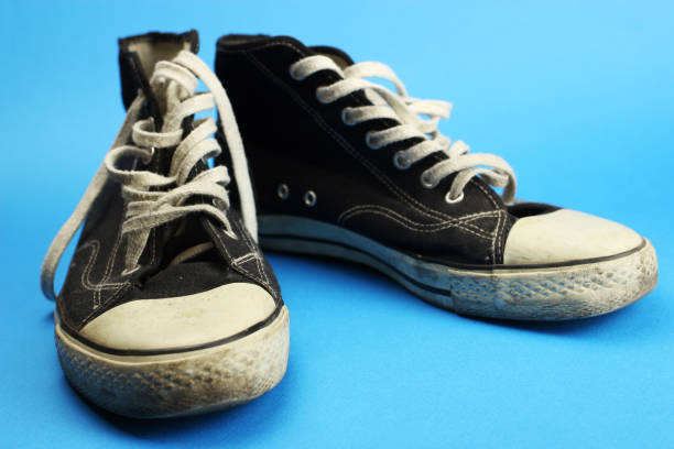 istock sneakers black old, worn, vintage on blue background 1219732070