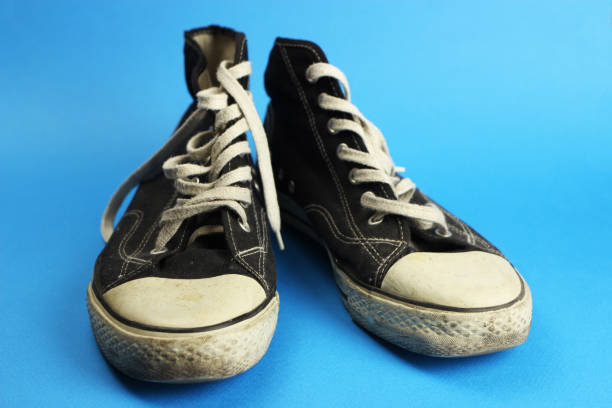 istock black old sneakers on blue background 1219732134