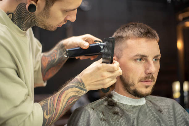 istock Hair stylist using an electric trimmer for hair cut 1219732142