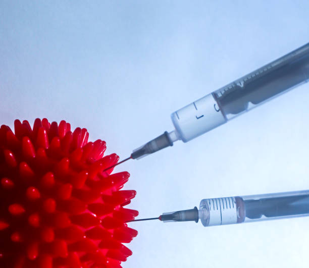 istock Syringe and red Coronavirus symbol. 1219732148