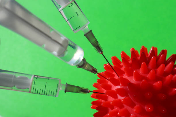 istock Syringe and red Coronavirus on a green background. 1219732185