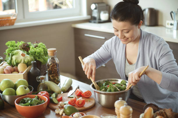 istock woman in the kitchen preparing food 1219735390