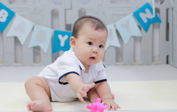 istock infant sitting play with ball in nursery 1219735721