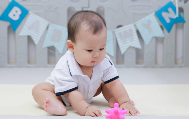 istock infant sitting play with ball in nursery 1219735743