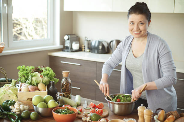 istock woman in the kitchen preparing food 1219737110