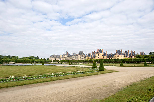 Fontainebleau (Seine-et-Marne, Ile-de-France, France) - Exterior of the ancient castle and park with  blue sky and white clouds