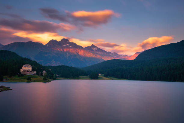 Sunset above lake St. Moritzersee with Swiss Alps and a mountain hotel St. Moritz, Switzerland - July 19, 2019 : Colorful sunset above lake St. Moritzersee with Swiss Alps and a mountain hotel and restaurant. Long exposure. maloja region stock pictures, royalty-free photos & images