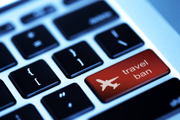 Travel ban  word and airplane icon on Computer Keyboard Keys