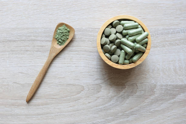 istock Herbal extract medicine tablets pills with capsules and powder or Fa thalai chon (Andrographis Paniculata), Acanthaceae in wooden bowl on wooden background, Medical and healthcare concept 1219739589